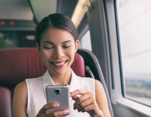 A passenger looking at a phone while on a bus
